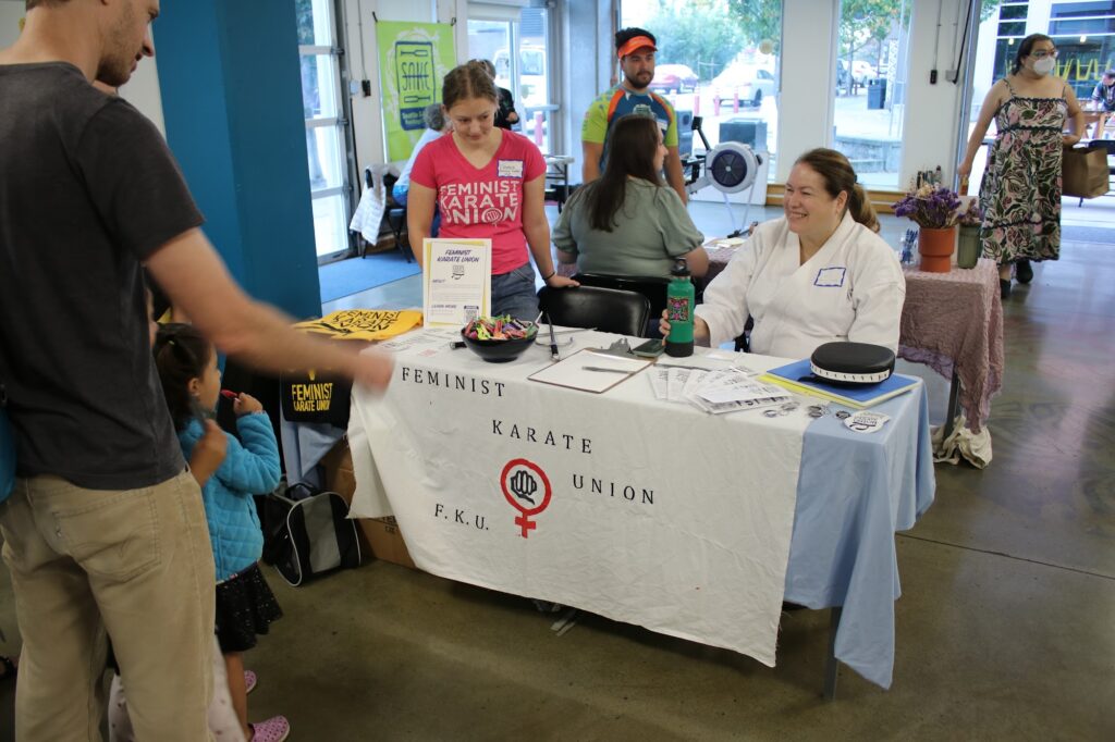 Neighbors visiting a club table at the South Seattle Club Fair